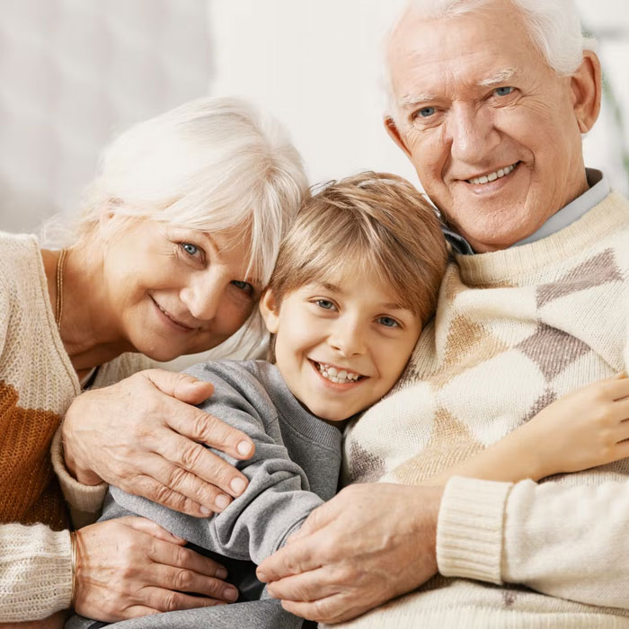 grandparents hugging grandson and smiling